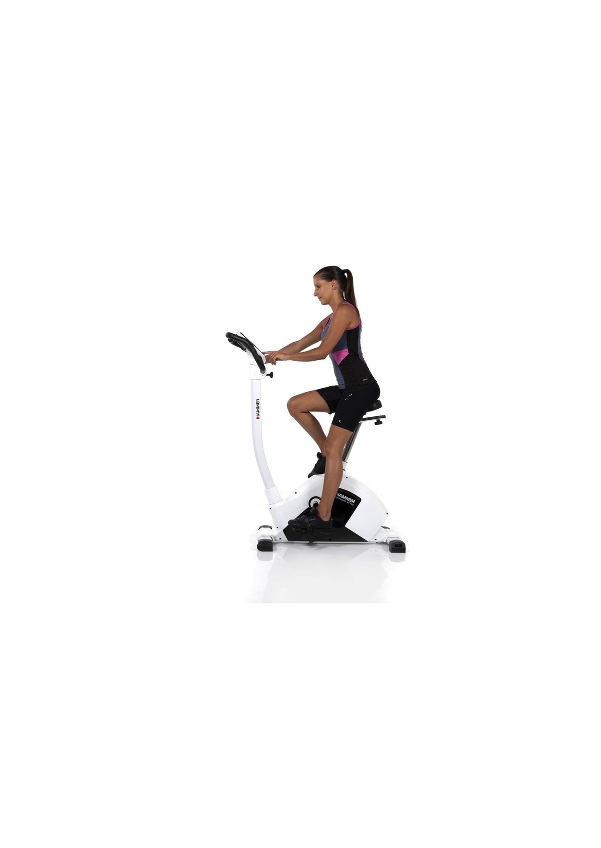 Woman cycling on an exercise bike against a white background