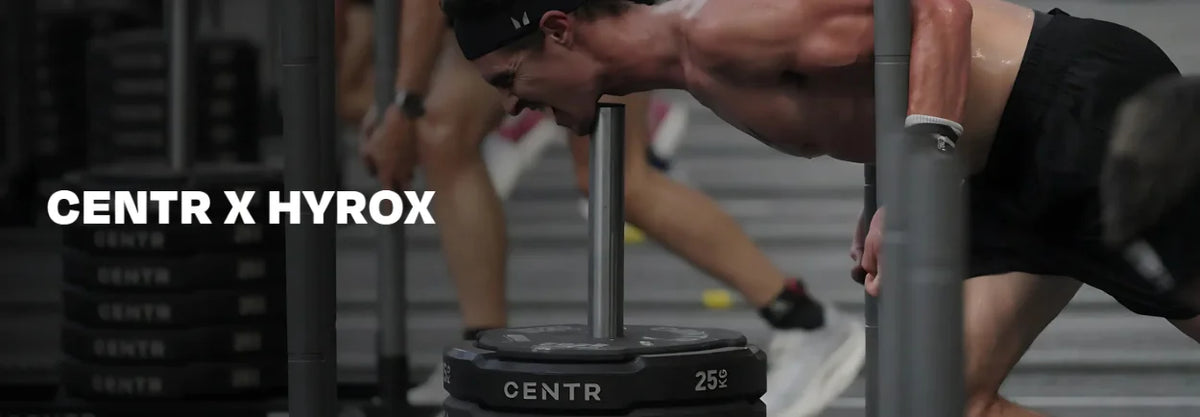Athletes training with gym equipment at a HYROX event