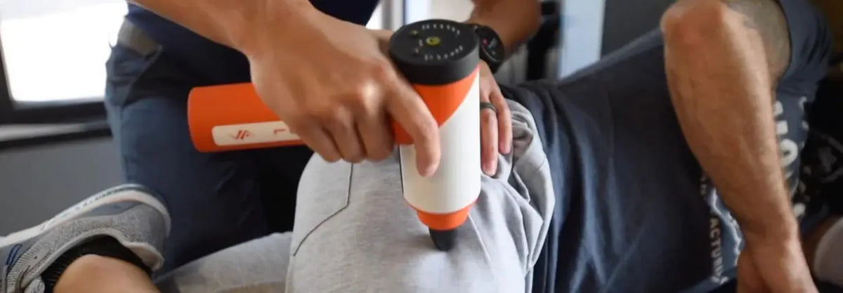Massage gun being used on a thigh
