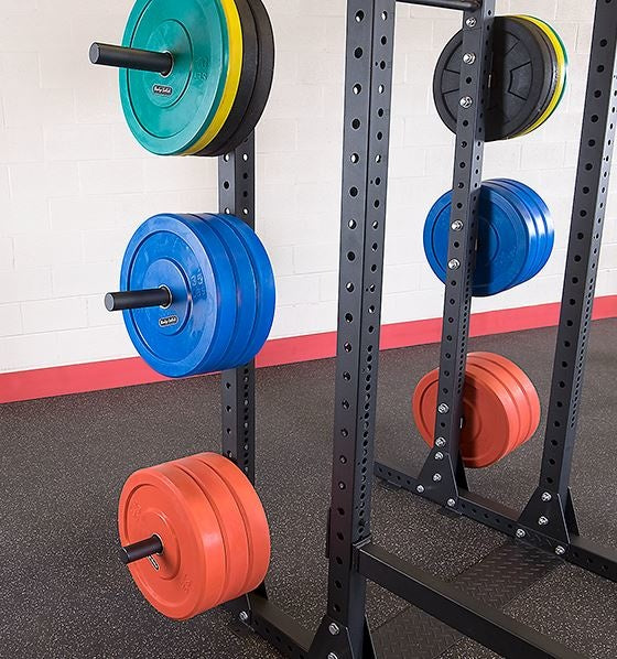 Close-up van gekleurde gewichtsschijven opgeborgen aan een Body-Solid power rack