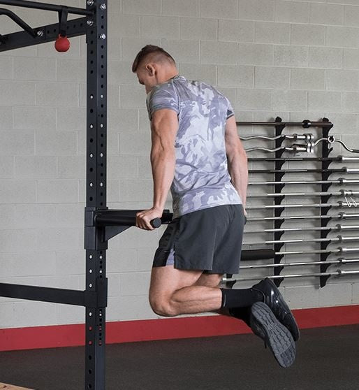 Man doet een dip aan de steunen van het Body-Solid power rack