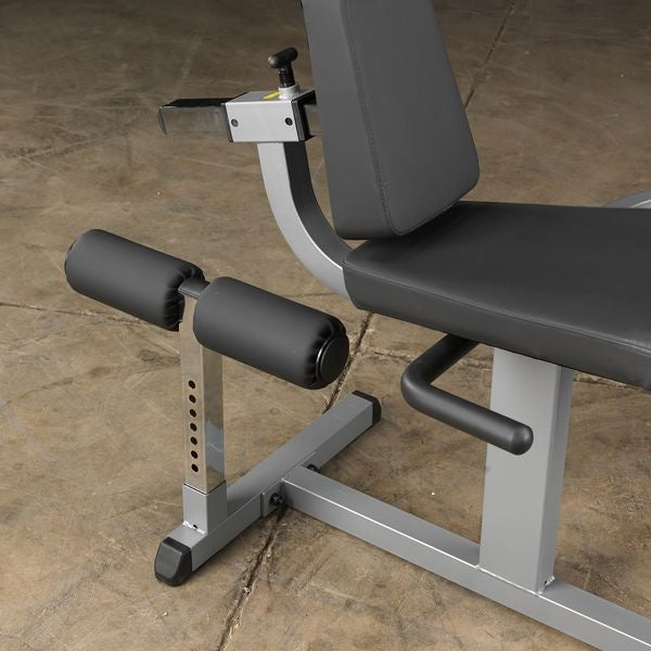 Detail van de rugleuning, zitting en twee beenrollen van een fitnessmachine.