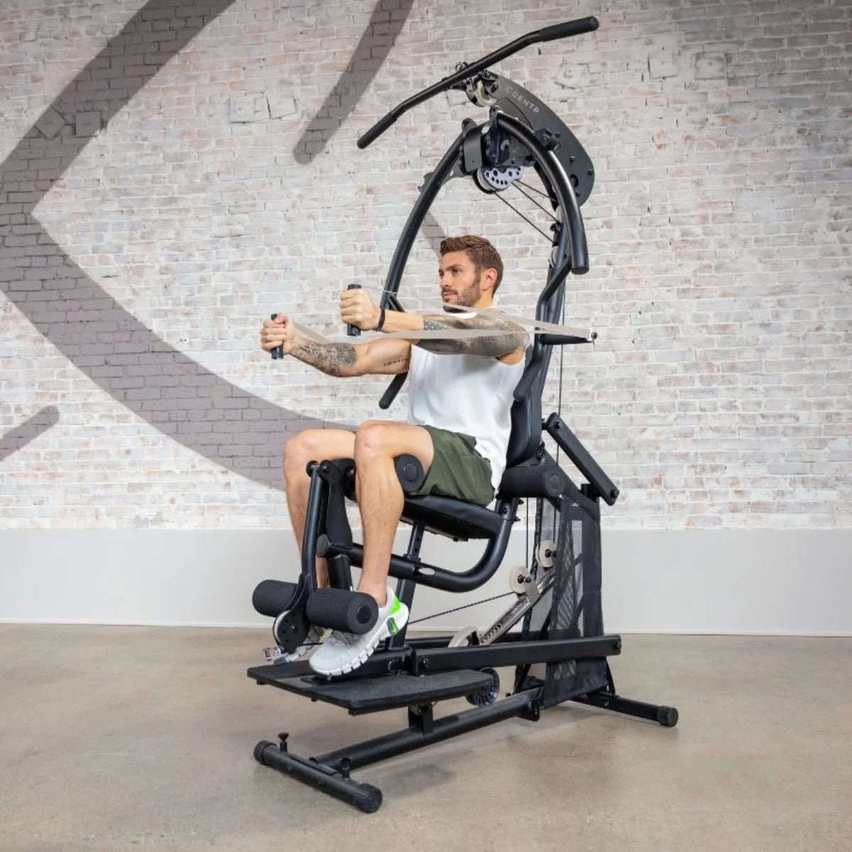 Man zit aan een bodyweight-krachtstation met zijn handen bij de handgrepen.