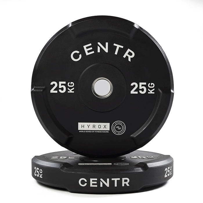 Twee zwarte CENTR-bumperplates van 25 kg, één rechtop achter de andere, op een witte achtergrond.
