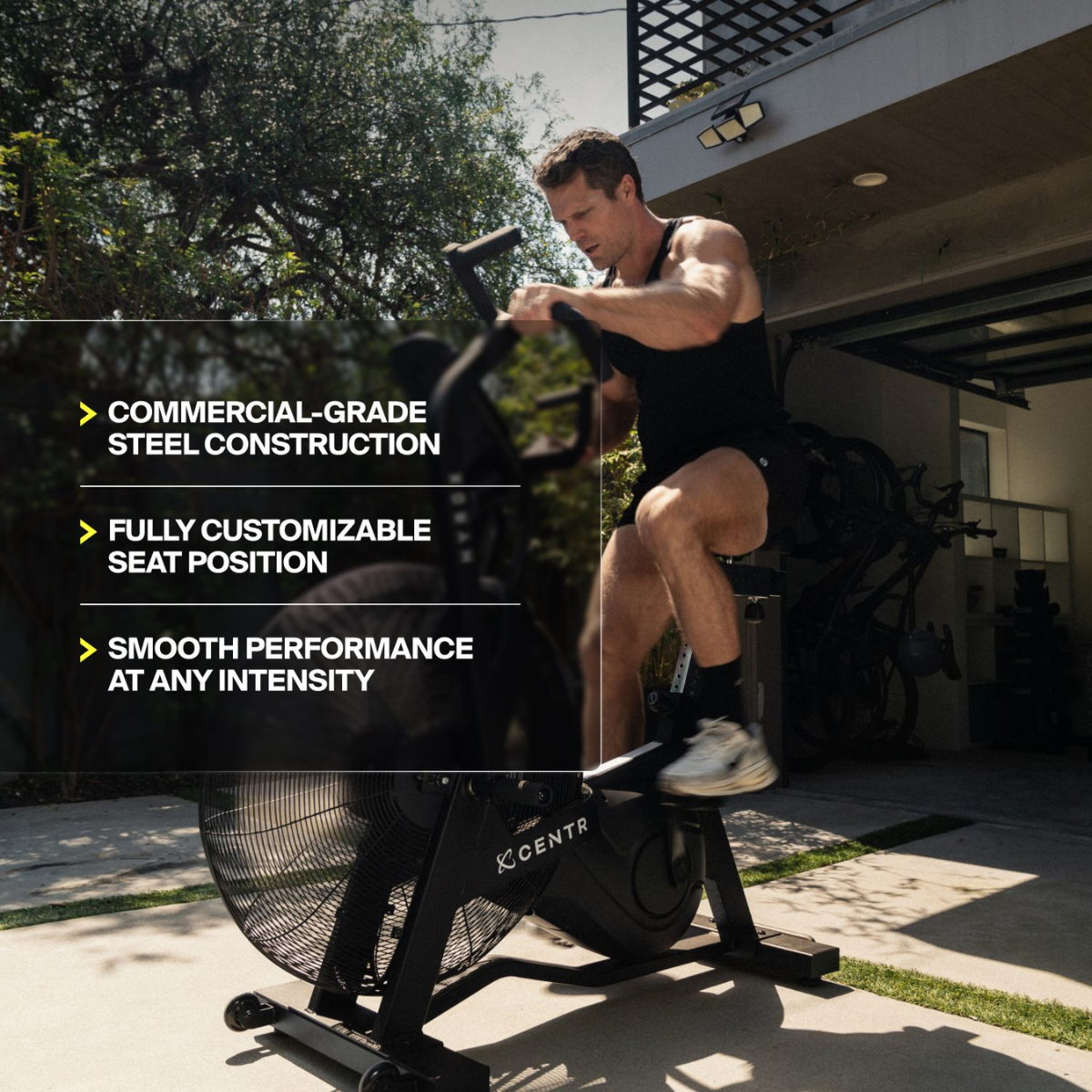 Man traint buiten op een airbike; tekst noemt stalen constructie, verstelbare zitting en prestaties.