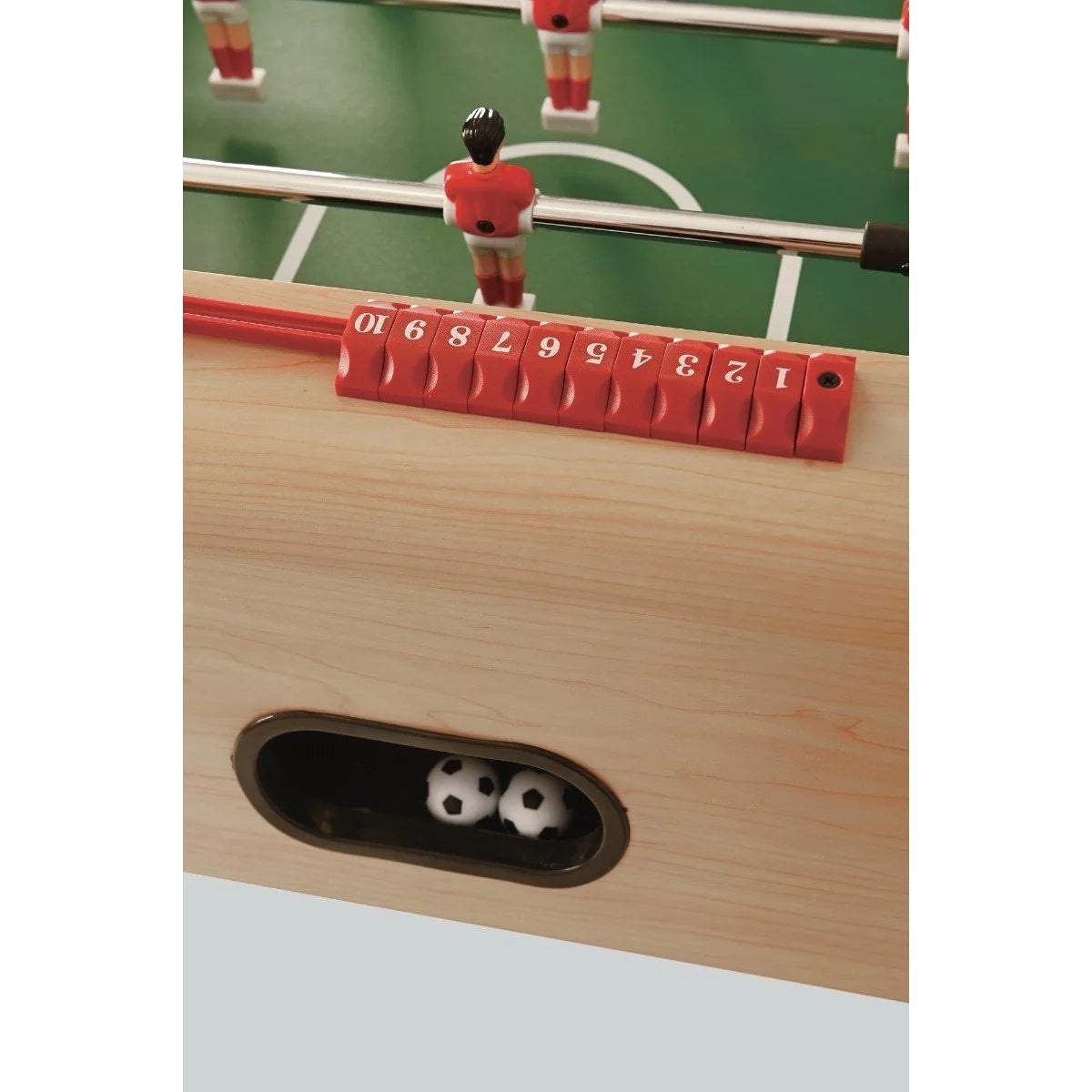Rode scoreteller en zwart doelgat in de licht houtkleurige zijwand van de voetbaltafel.