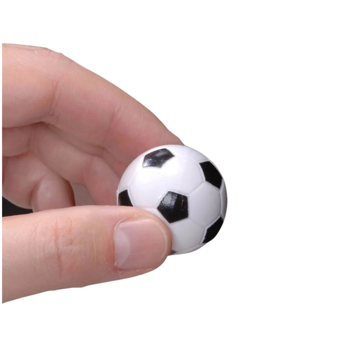 Hand houdt een kleine zwart-witte voetbaltafelbal vast tegen een witte achtergrond.