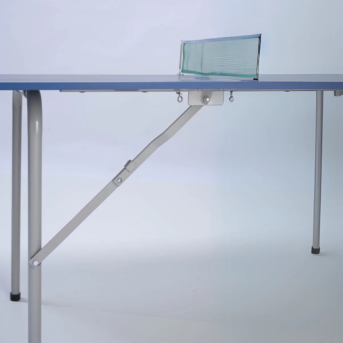 Zijaanzicht van de blauwe tafeltennistafel met metalen poten, schoren en net.