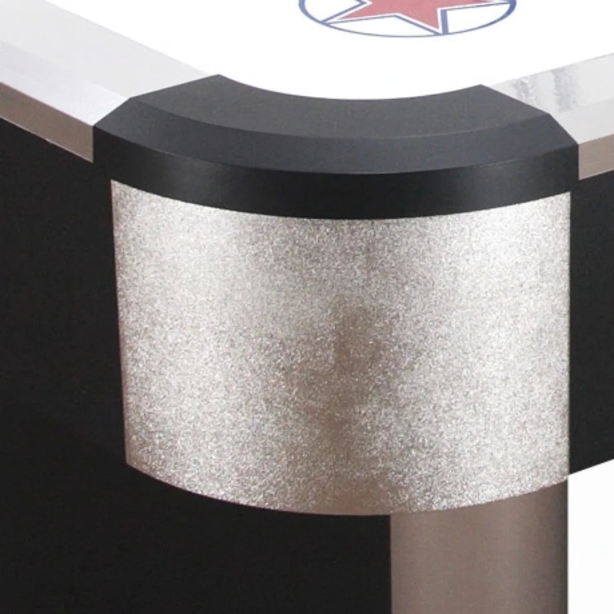 Close-up van de afgeronde zwarte hoekrand en zilverkleurige zijkant van een airhockeytafel.