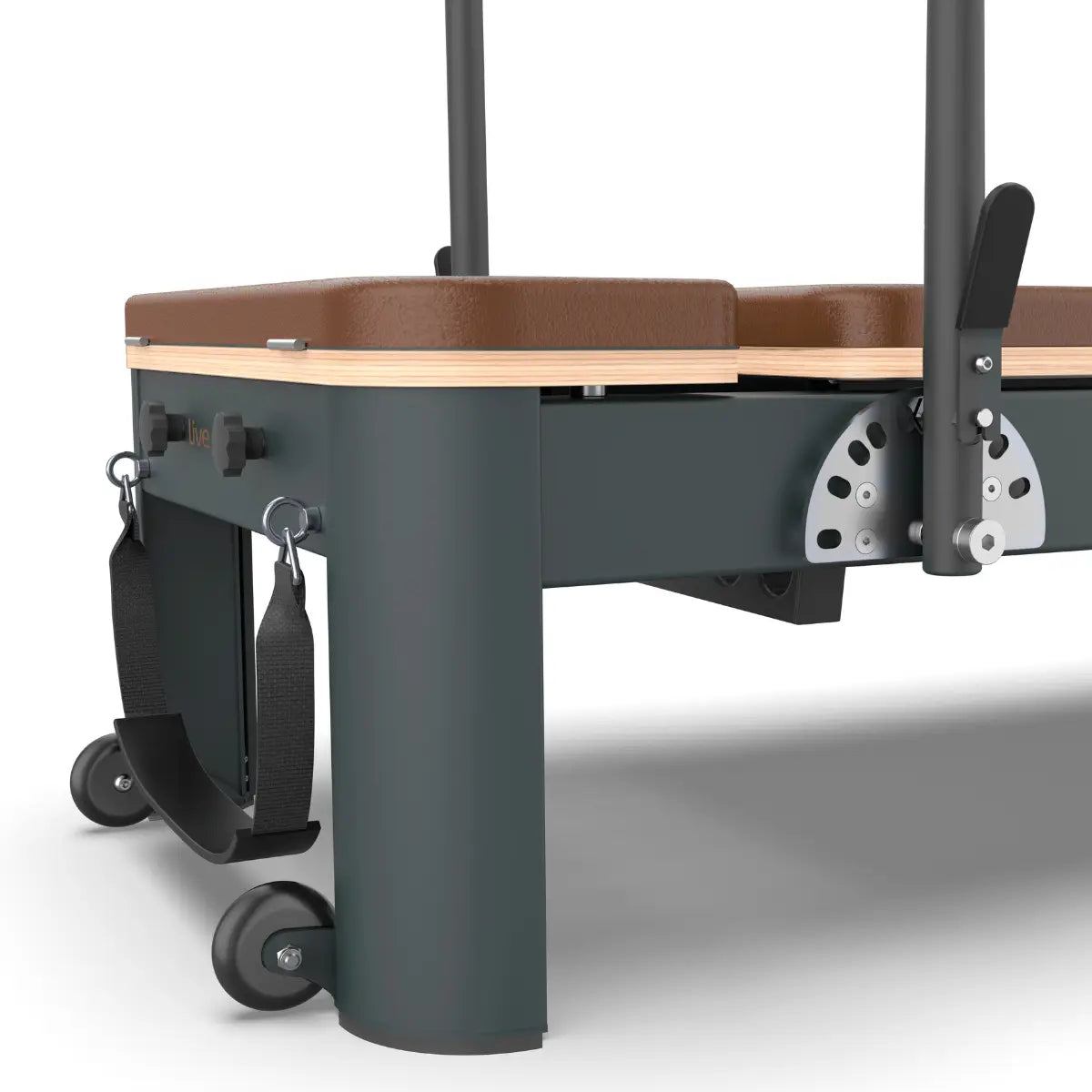 Close-up van de metalen poot met transportwielen en het bruine kussen van een Pilatesreformer.