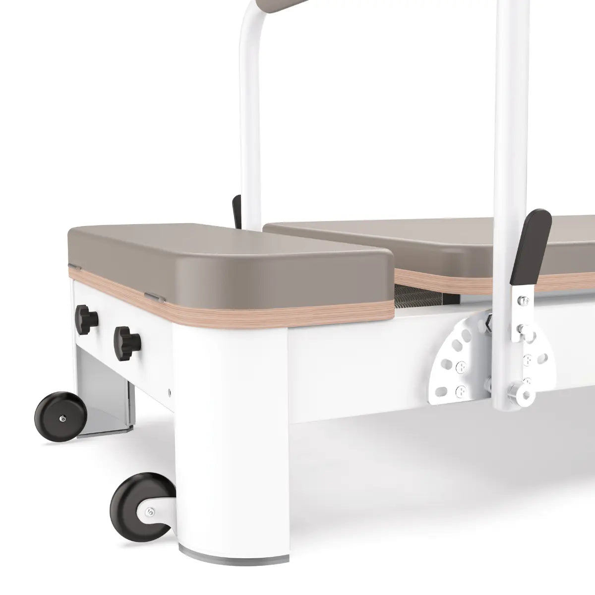 Close-up van een metalen kabel en katrol naast de taupekleurige bekleding van een Pilatesreformer.