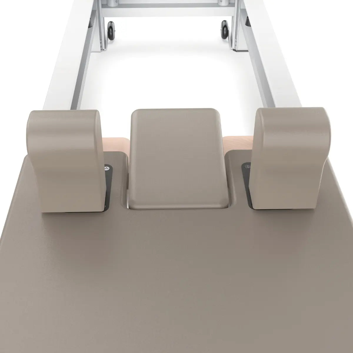 Close-up van een transportwiel en witte metalen poot onder een Pilatesreformer.