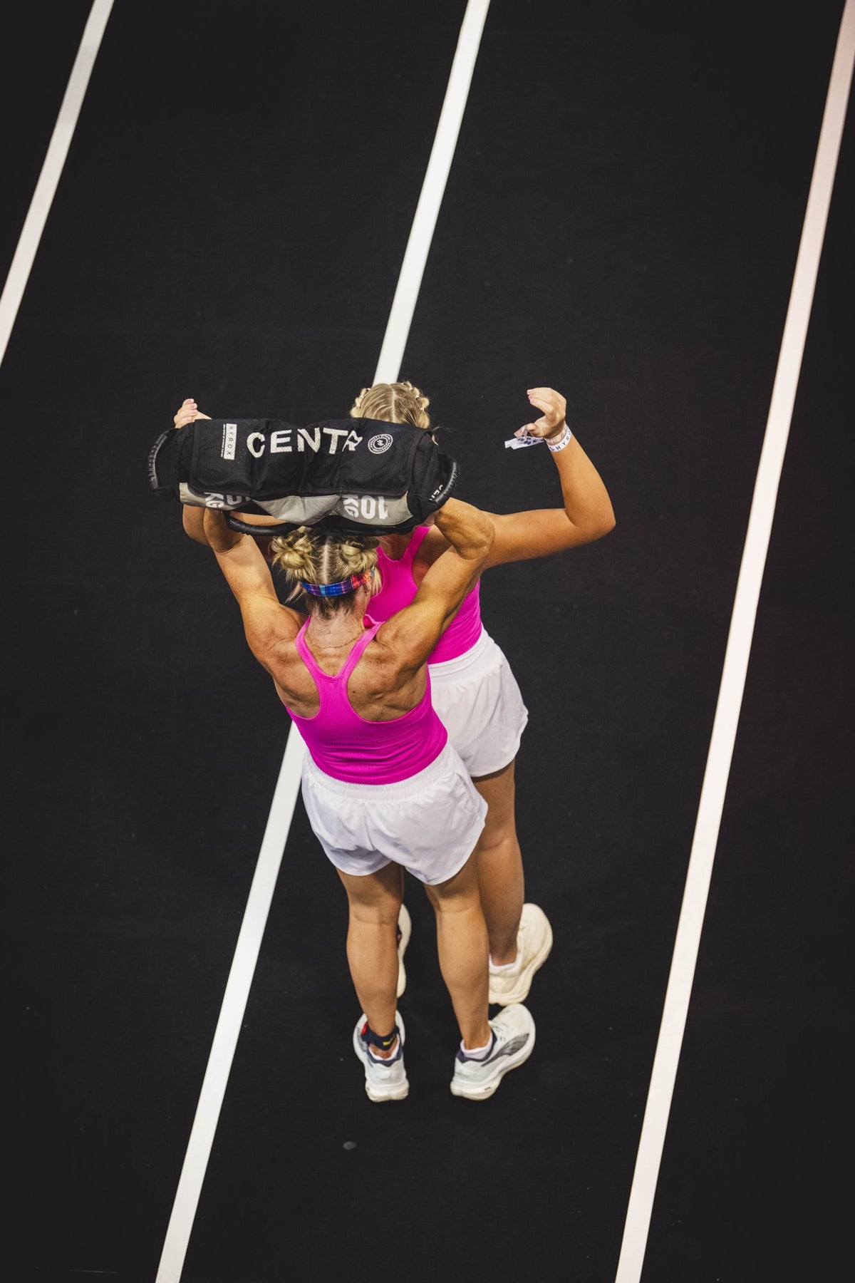 Atleet met een Centr x HYROX sandbag op de wedstrijdbaan