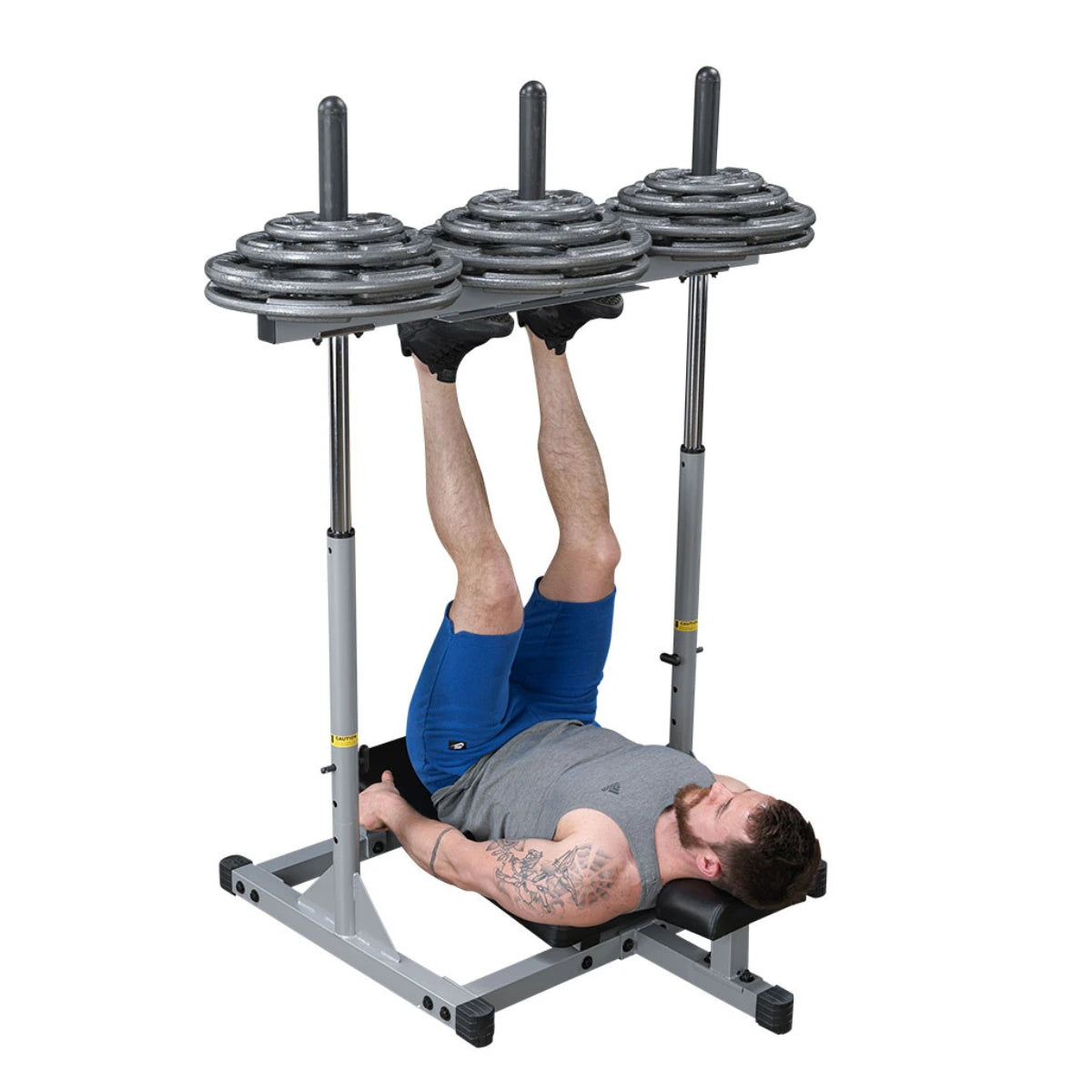 A man lies beneath a vertical leg press with both feet against the platform.