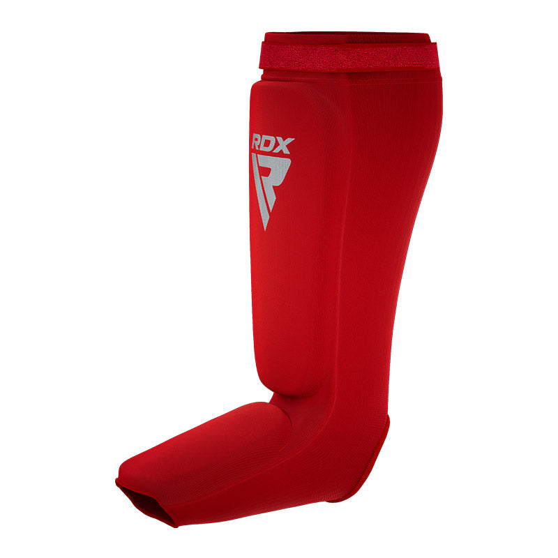 Red shin and instep guard with a white RDX logo, angled from the front against a white background.