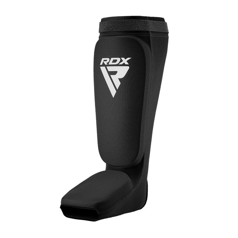 Black shin and instep guard with a white RDX logo, angled from the side against a white background.