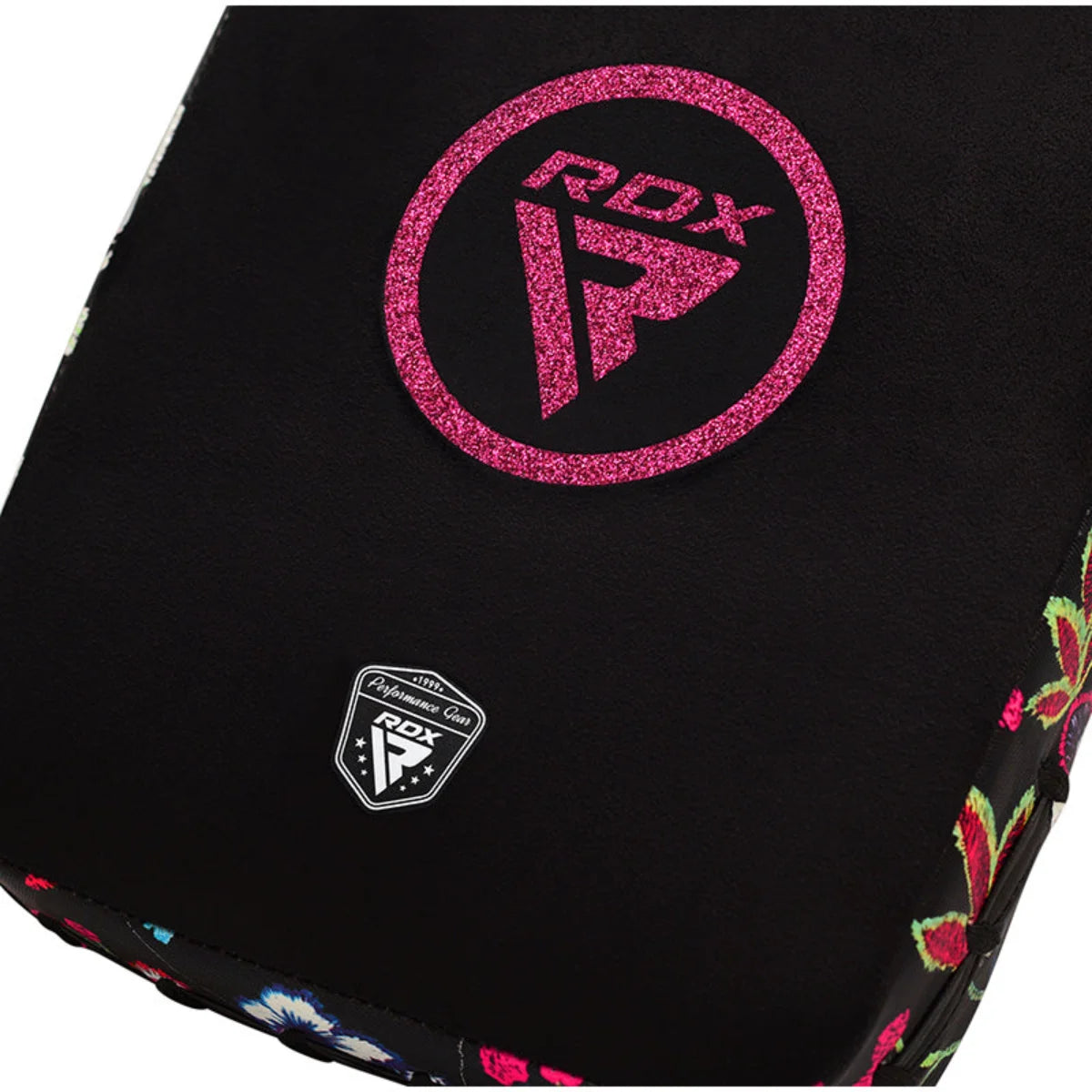 Close-up van een zwarte handpad met roze RDX-logo en klein embleem.