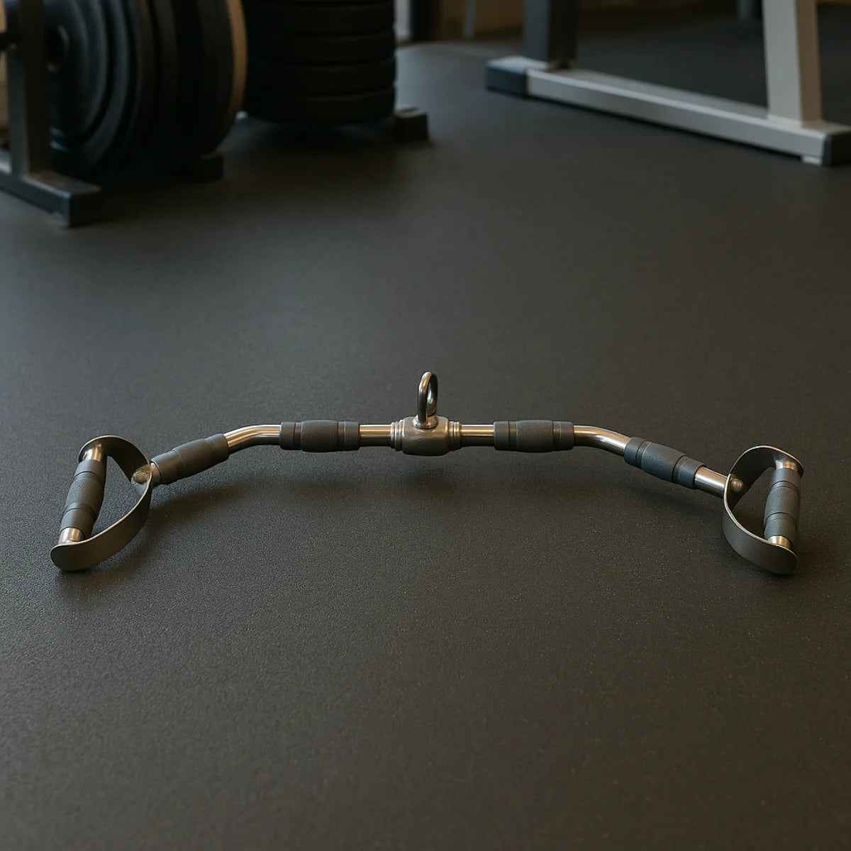 Gebogen metalen kabelstang met zwarte gripdelen op een donkere vloer; op de achtergrond staat fitnessapparatuur.