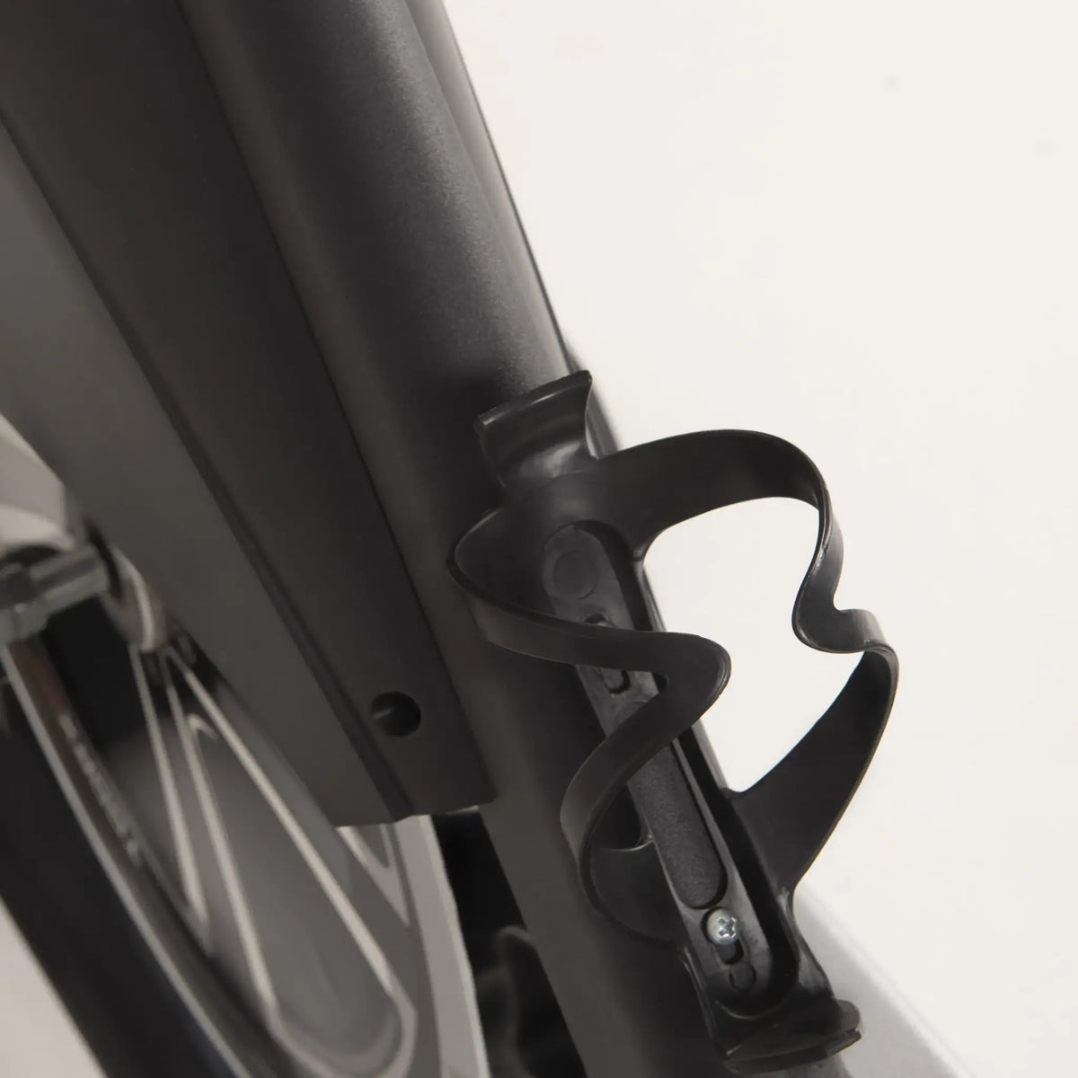 Zwarte bidonhouder aan het frame van een spinningfiets.