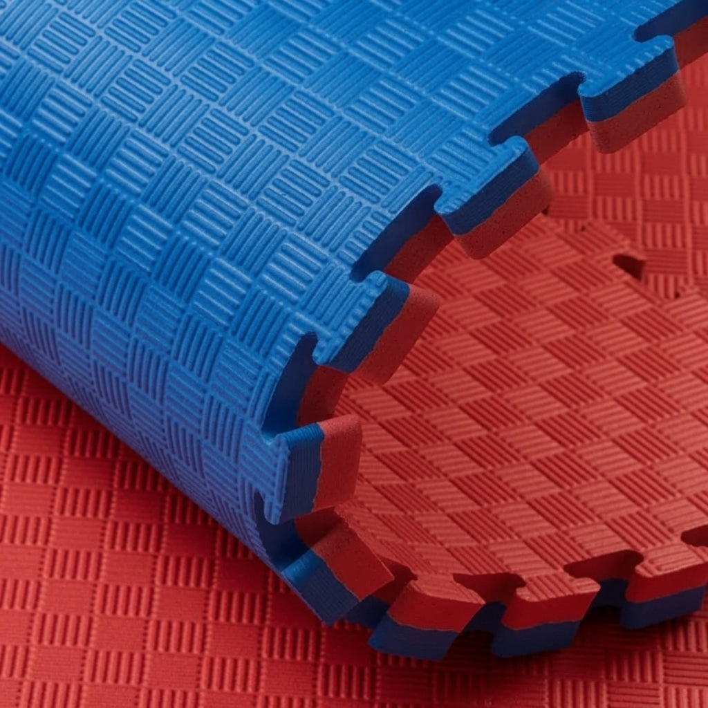 Opgerolde puzzelmat met blauwe bovenzijde, rode onderzijde en getande randen.