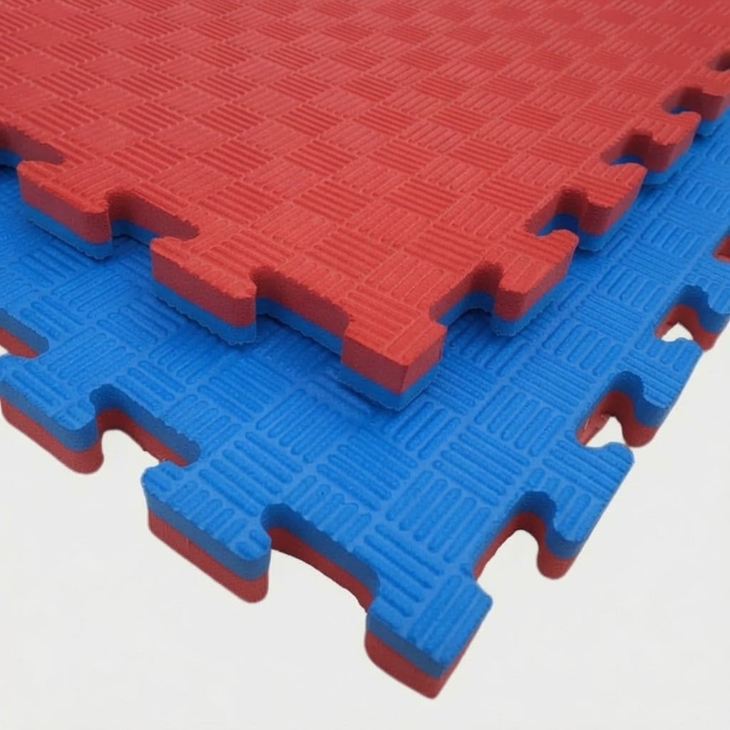 Hoek van blauwe en rode puzzelmatten met in elkaar grijpende randen en geribbeld oppervlak.