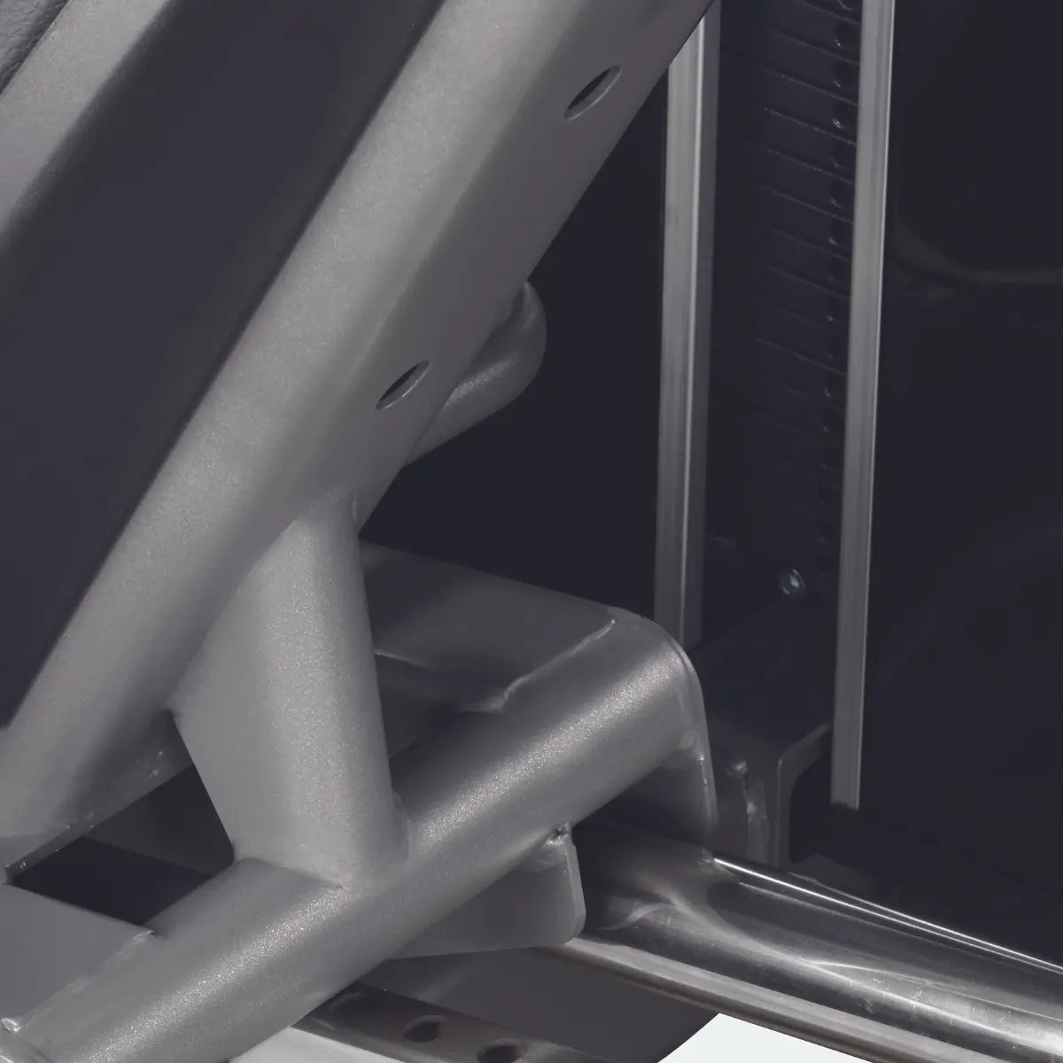 Close-up van de rail en metalen verbinding onder de zitting van een leg press.