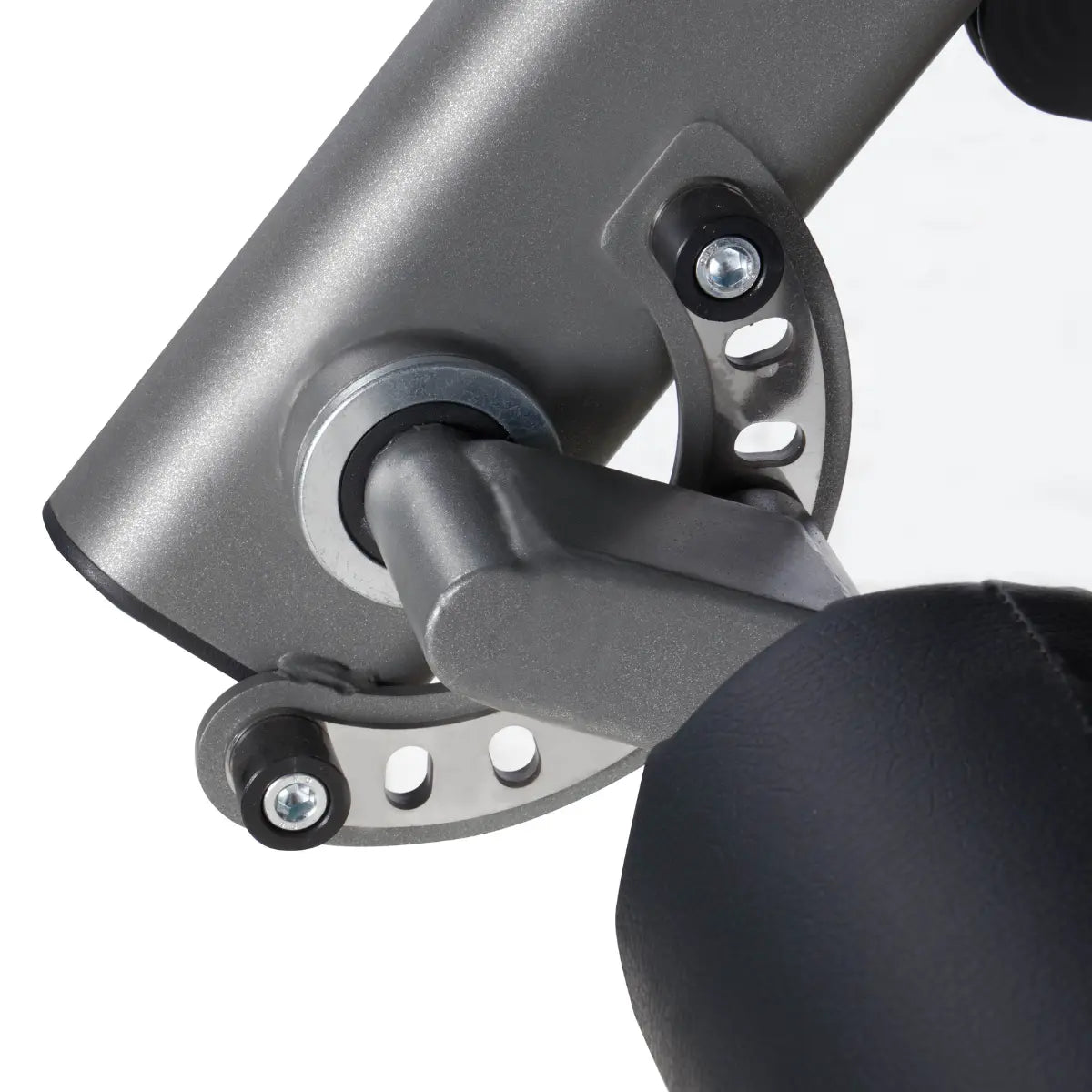 Detail van het metalen scharnier en de bevestigingsbout van een leg extension-machine.