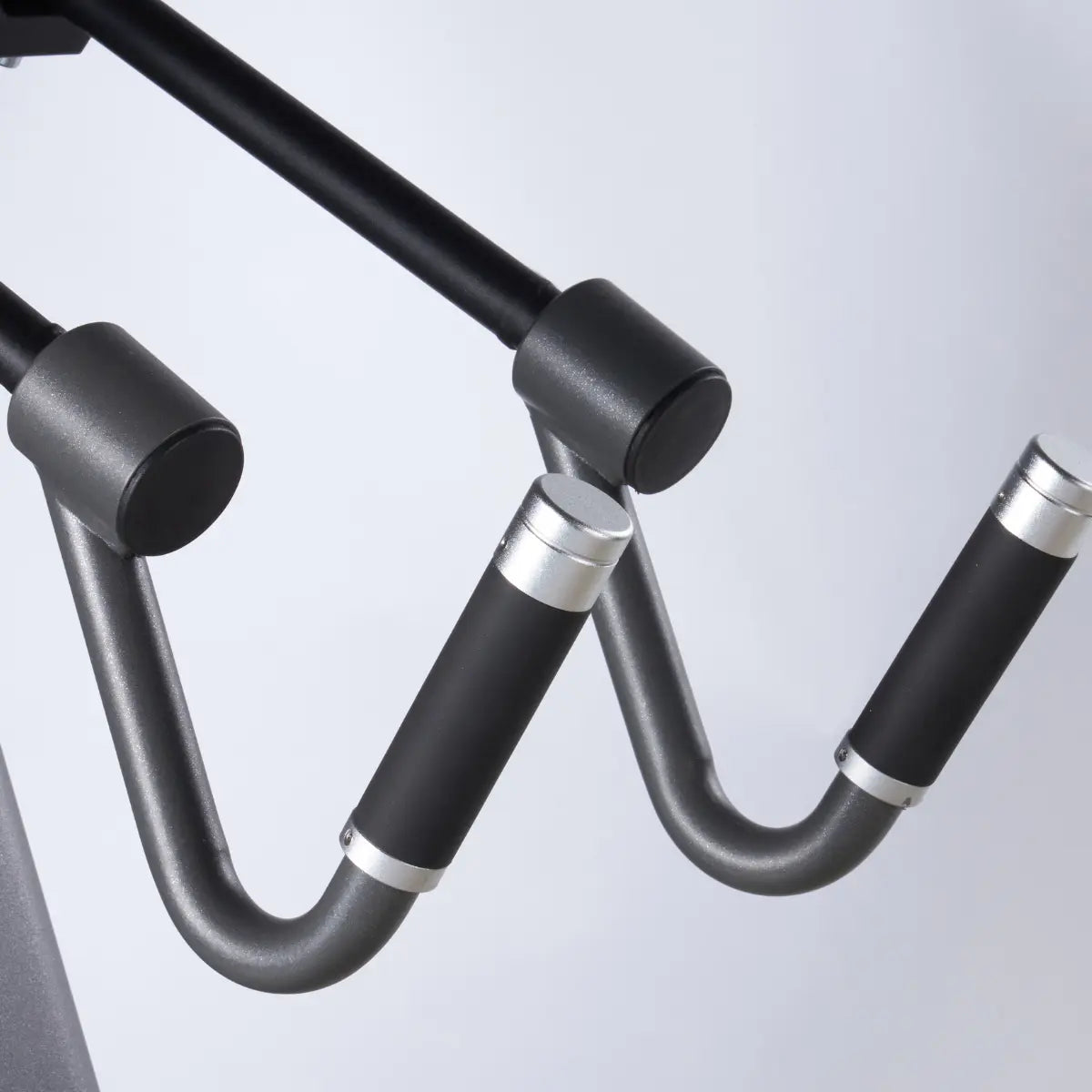 Twee gebogen metalen kabelgrepen met zwarte handvatten.