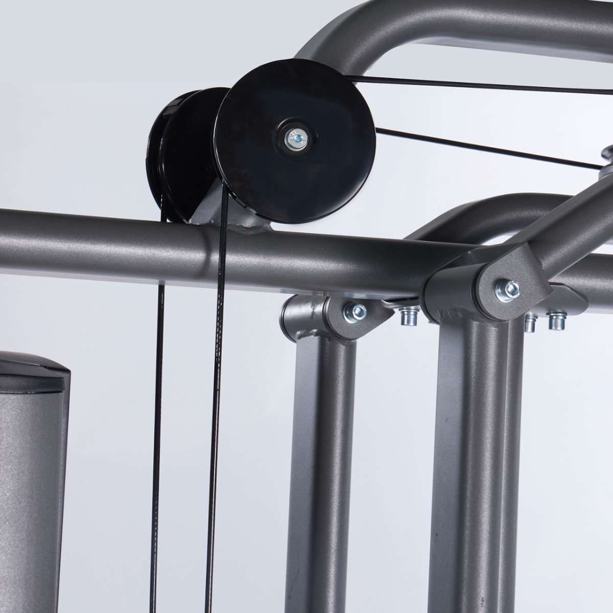 Close-up van gevoerde zitting, rolsteunen en verstelknop van een krachttrainingsmachine.
